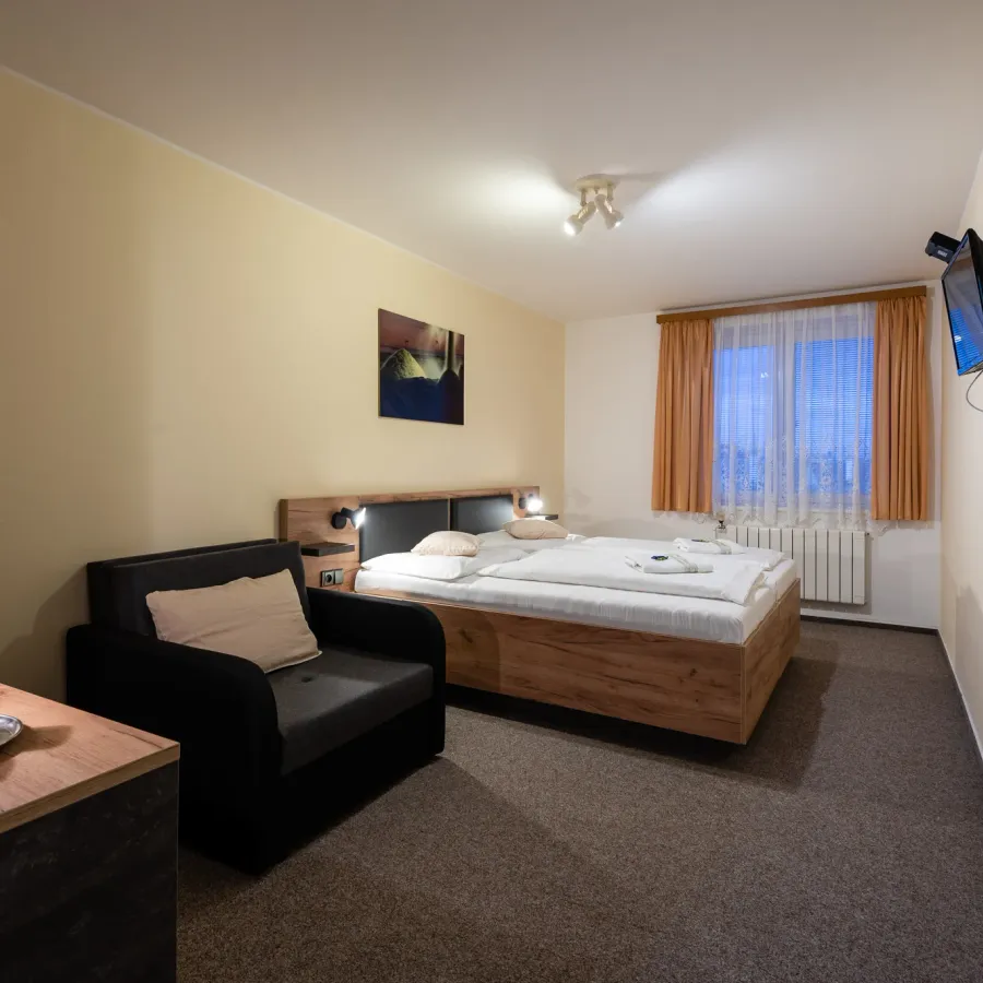 Room with a double bed and an armchair
